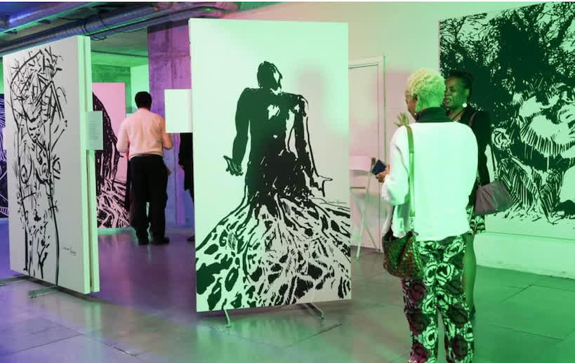 Visitors viewing artworks at an Aduma Adan therapeutic art exhibition